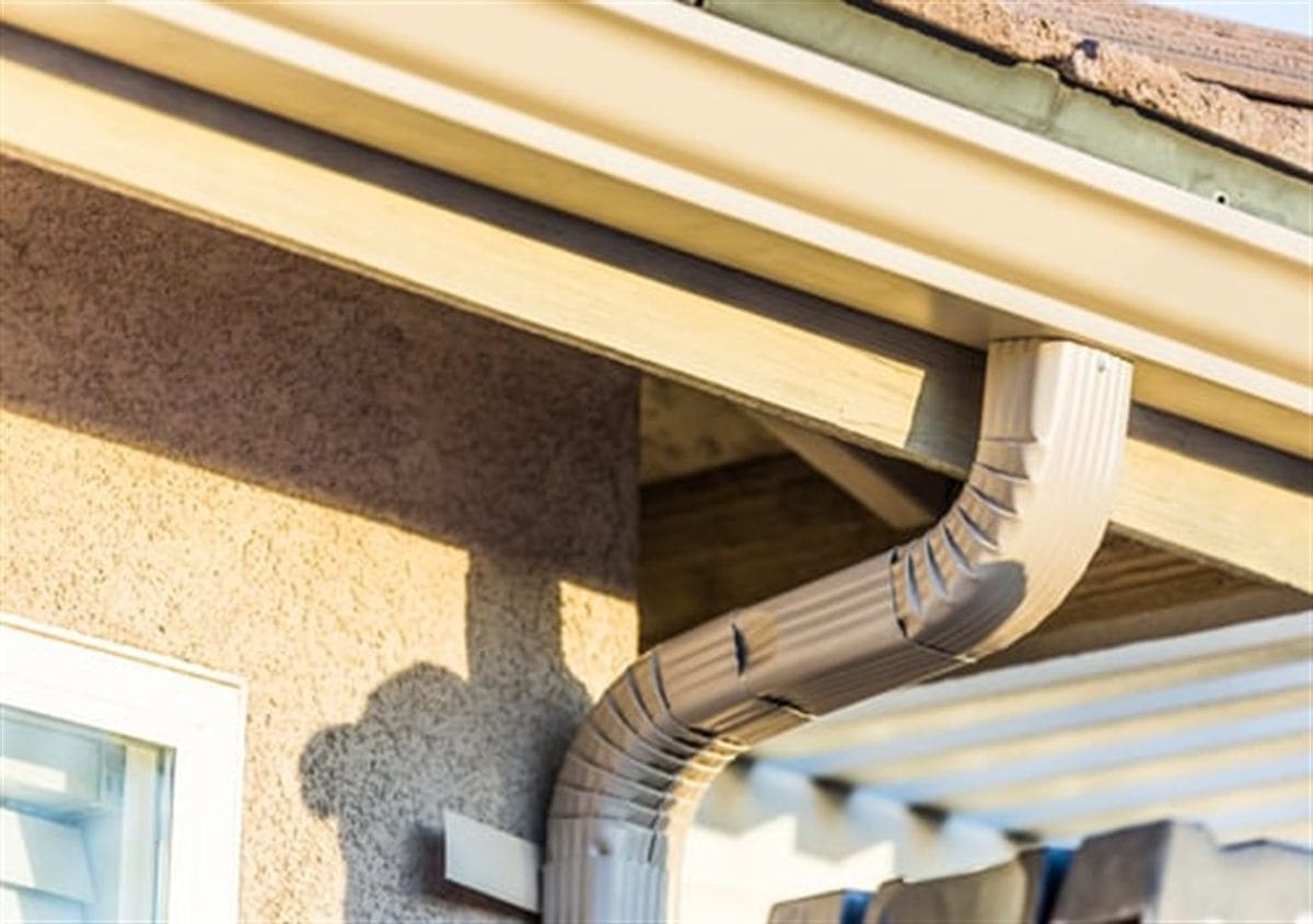 Clean gutter and downspout system installed along a home's roofline