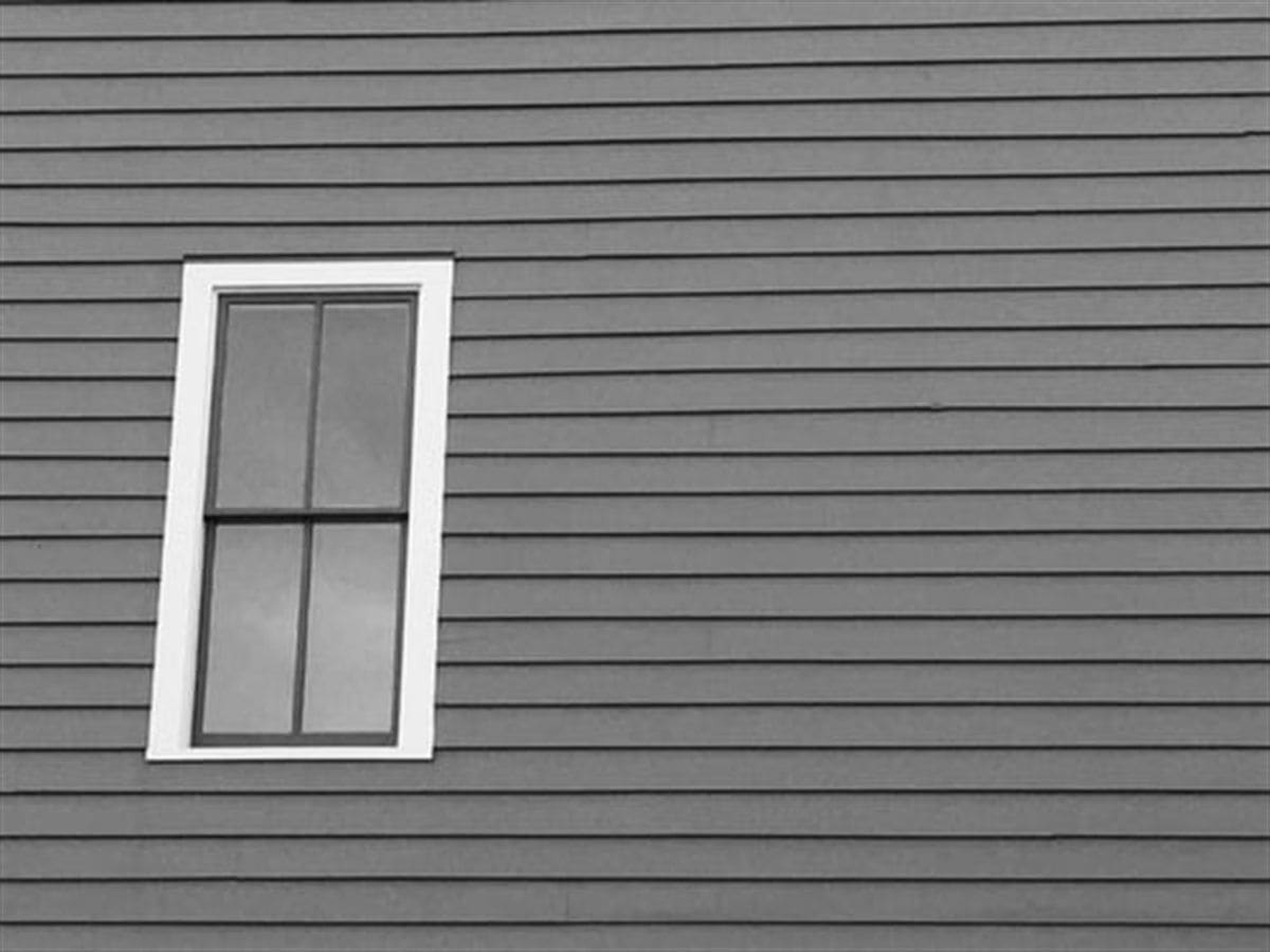 Close view of lap siding and a window frame on a residential exterior
