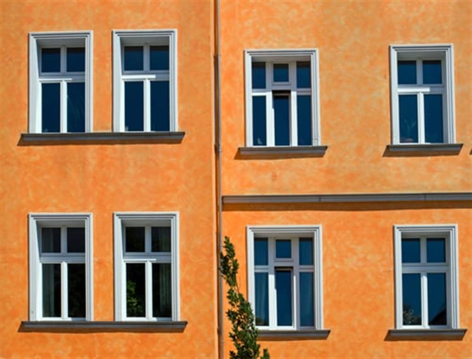 Painted exterior facade with rows of white-trimmed windows