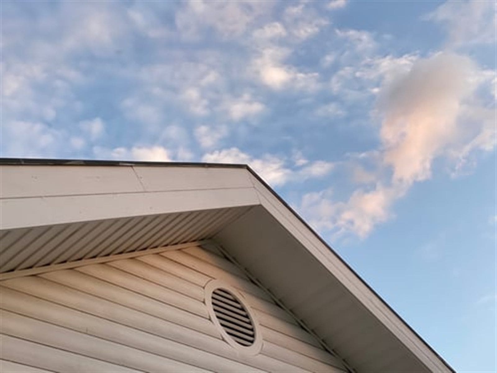 Restored soffit and fascia along a residential roofline against a clear sky